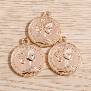 Vue macro détaillée de trois pendentifs pièces romaines en or rose sur fond de bois