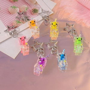 Detail of 6 colorful acrylic robot keychains with star-shaped clips on a pink background