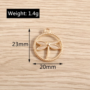 Macro view showing dimensions of a golden dragonfly pendant with rope border, 23mm by 20mm