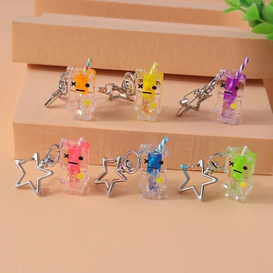 Close-up of six colorful robotic cup keychains with star-shaped clips and liquid glitter