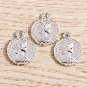 Détail macro de trois pendentifs pièces romaines en argent avec relief Elizabeth II
