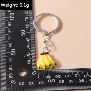 Detail of banana keychain with resin texture and metal ring measured by a ruler
