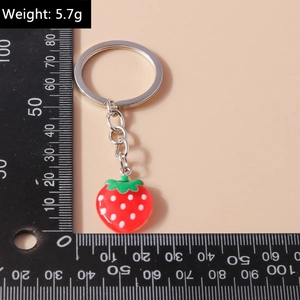 Detail view of 5.7g red strawberry keychain pendant with silver chain and measurement tool