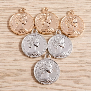 Détails macro des breloques pièces d'or et d'argent avec relief de la reine Elizabeth II
