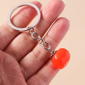 Close-up of a realistic persimmon pendant keychain with a silver metal ring and chain