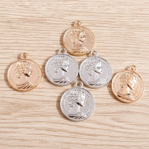 Vue détaillée de breloques en forme de pièces romaines dorées et argentées pour bijoux