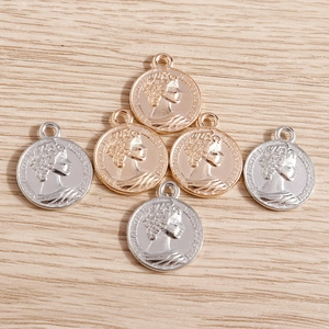 Vue détaillée de pendentifs pièces en or et argent avec relief de la reine Elizabeth II