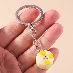 Detailed view of handmade simulation banana slice keychain with silver ring for bags