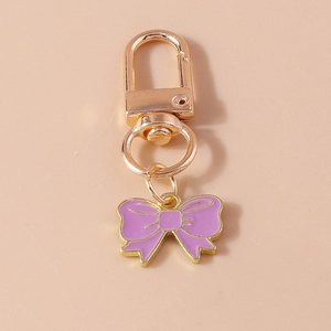 Détail d'un pendentif nœud en émail violet avec fermoir doré pour sacs à main