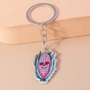 Detail of Halloween acrylic keychain featuring a spooky pink corn skull pendant with red eyes