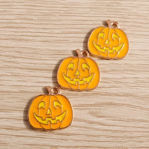 Makro-Detail von Kürbis-Anhängern mit orangefarbener Emaille und goldenen Kanten für DIY