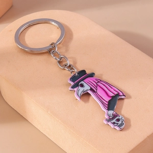 Detailed view of pink plague doctor keychain with skull accessory on beige display