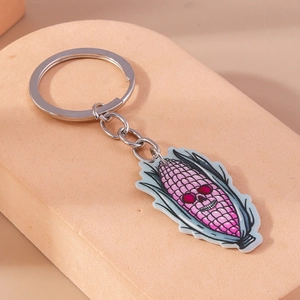 Detail shot of a purple corn skull keychain with a silver metal ring on a neutral block