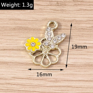 Détail macro du pendentif fleur et papillon doré avec strass blancs, taille 19mm x 16mm