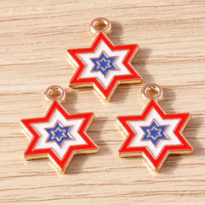 Three enamel star pendants with red white and blue layers on a light wooden background