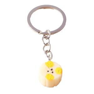 Creative fruit pendant keychain with silver ring and spotted off-white charm on white background