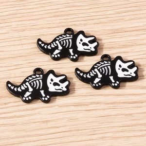 Detailed view of three triceratops skeleton charms with black and white enamel finish