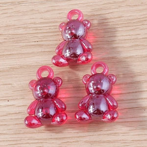 Close-up of translucent rose red resin bear charms with integrated loops for DIY jewelry