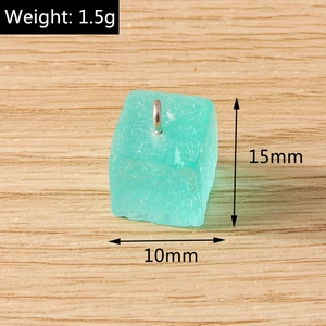 Vue macro d'un pendentif cube en résine vert menthe 15mm avec anneau en métal argenté