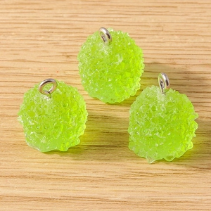 Vue macro de pendentifs sphériques en résine vert clair avec texture mate et anneaux argent