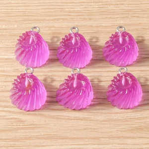 Détail de six pendentifs en résine violette avec crochets argentés sur fond de bois