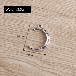 Detailed macro view of silver moon pendant with to the moon and back engraving