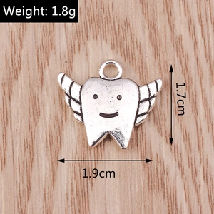 Macro shot of silver winged tooth pendant showing 1.9cm width and 1.7cm height dimensions