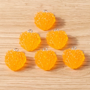 Vue détaillée de pendentifs cœur en résine orange avec texture sucre et anneaux argentés