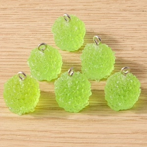 Gros plan de six pendentifs en résine vert fluo avec texture sucrée et anneaux argentés