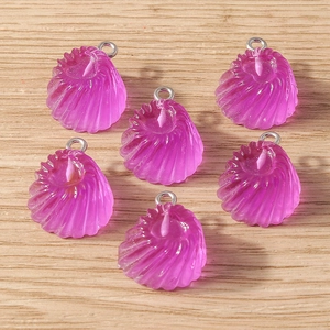 Vue macro de pendentifs coquillages en résine violette avec anneaux en argent DIY