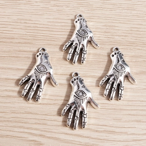 Macro shot of vintage silver Hamsa pendants with All-Seeing Eye and mystic symbols