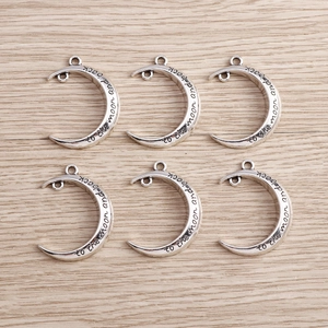 Set of 6 silver moon charms with to the moon and back engraving on wood background