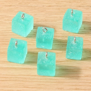 Vue détaillée de breloques cubes en résine givrée vert menthe avec anneaux argentés