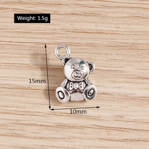Detail of a 15mm silver vintage bear charm with bowknot for DIY jewelry making