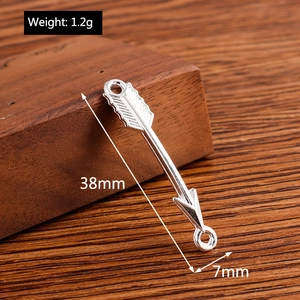 Vue macro d'un pendentif flèche argentée avec texture plume et taille 38mm x 7mm