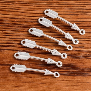 Détail macro de six connecteurs de flèche vintage en alliage argenté sur bois