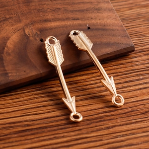 Pendentifs flèche en alliage doré pour bijoux DIY sur fond de bois vintage élégant