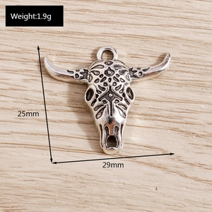 Macro detail of a bull skull pendant in vintage silver with bohemian engravings