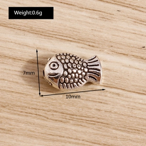 Macro shot of 10x7mm vintage silver fish bead for DIY jewelry with scale texture