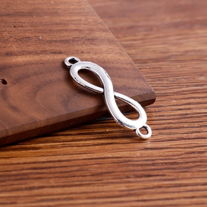 Macro detail of infinity symbol connectors with double loops on wood background