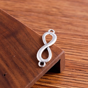 Close-up of infinity shape double-hole jewelry connectors with polished silver finish