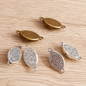 Detailed view of leaf-shaped evil eye connectors in antique bronze and silver finish