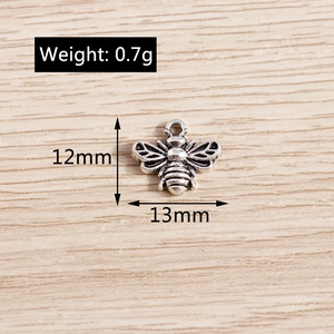 Detailed macro view of bee shaped alloy pendant showing dimensions of 12mm by 13mm