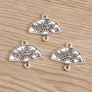 Detail of silver alloy fan pendants with plum blossom relief and dual loops for DIY jewelry