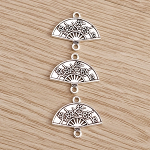 Detailed macro view of antique silver fan-shaped connectors with floral relief for DIY jewelry