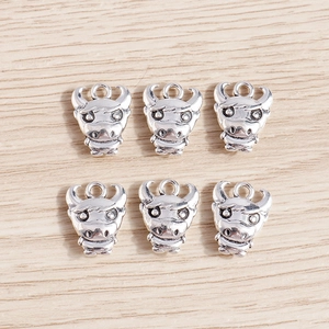 Detail of six retro silver bull head pendants with relief texture for DIY jewelry making