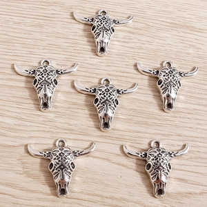 Set of six vintage antique silver bull skull pendants with intricate tribal engravings