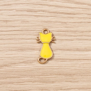 Détail d'un pendentif chat en émail jaune avec bordures dorées pour création de bijoux