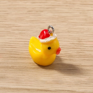 Gros plan détaillé d'un pendentif canard jaune en résine portant un bonnet de Noël festif