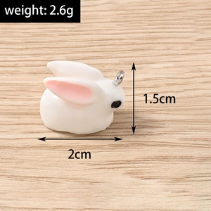Detail of a cute 3D bunny charm with metal ring and dimensions on wooden background